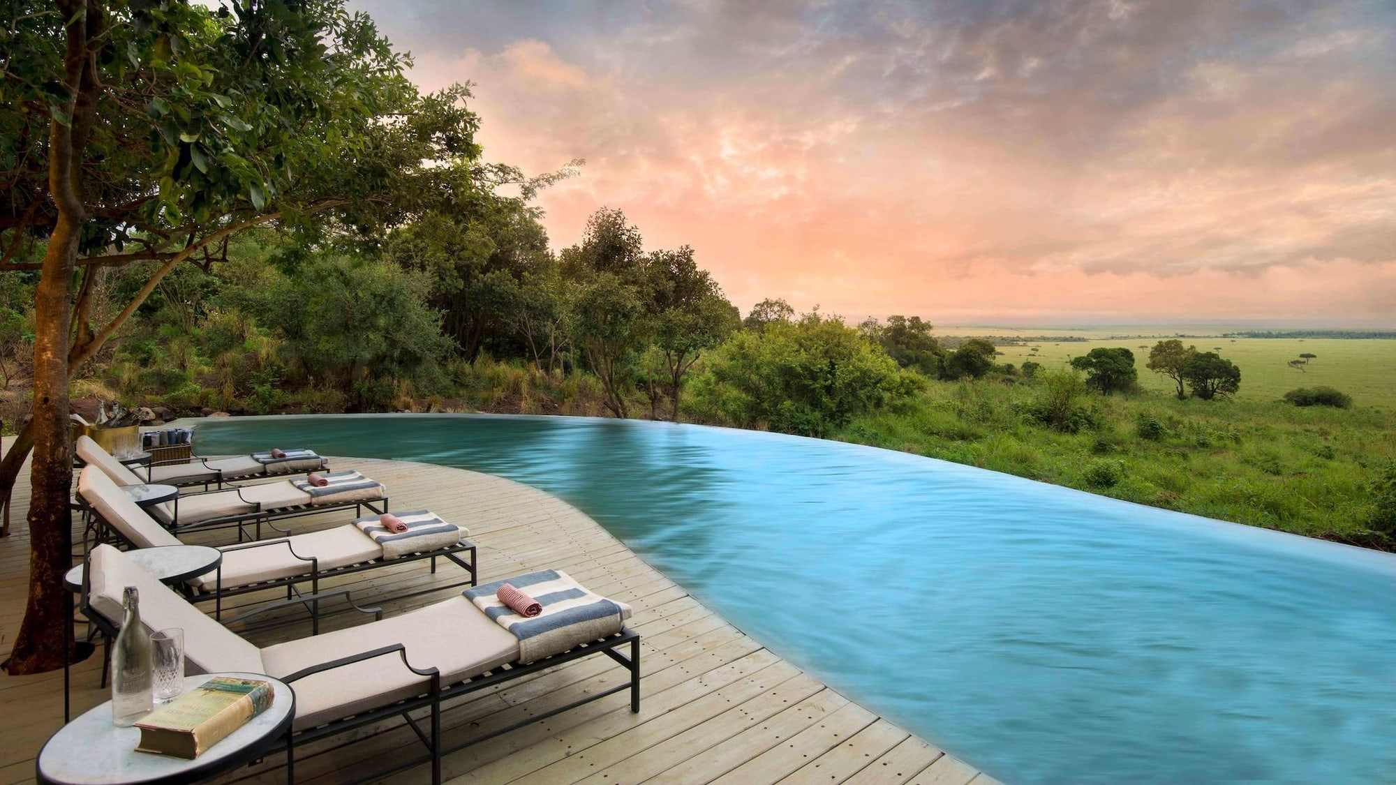 Infinity pool and sun loungers overlooking the plains at a safari lodge