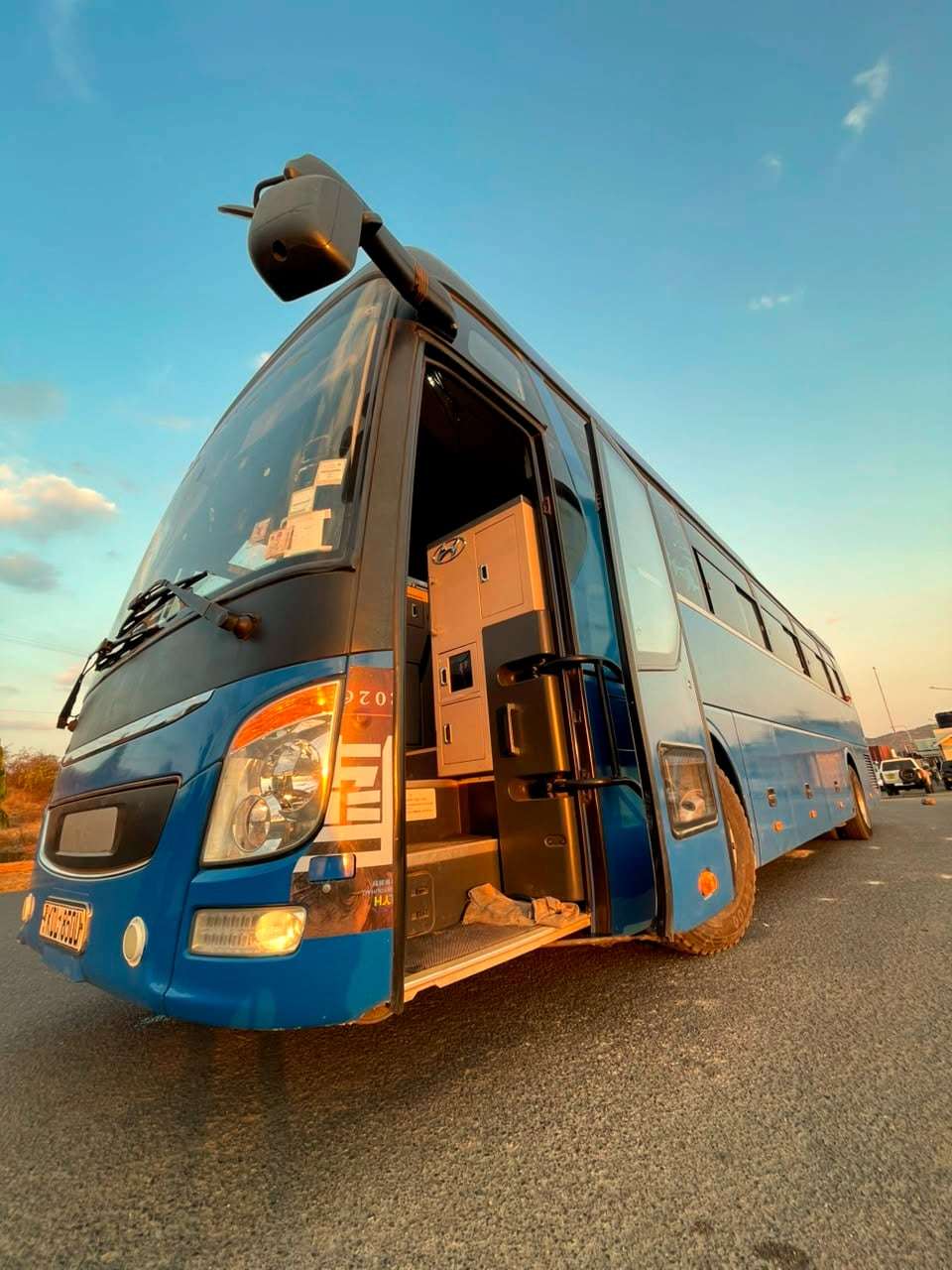 Front view of the Omosh tour bus with its door open, ready for boarding