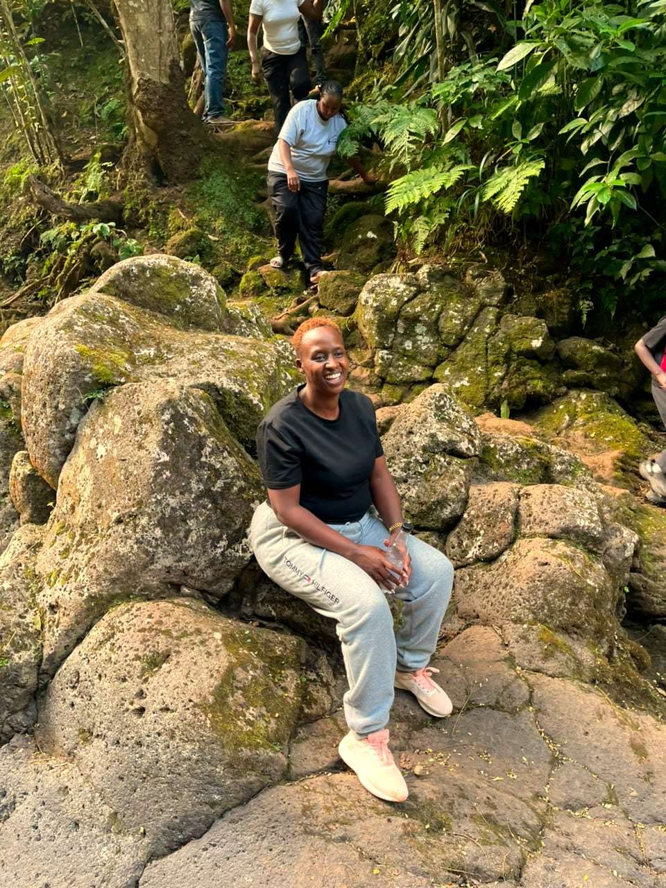 A smiling traveller resting on rocks during a forest hike